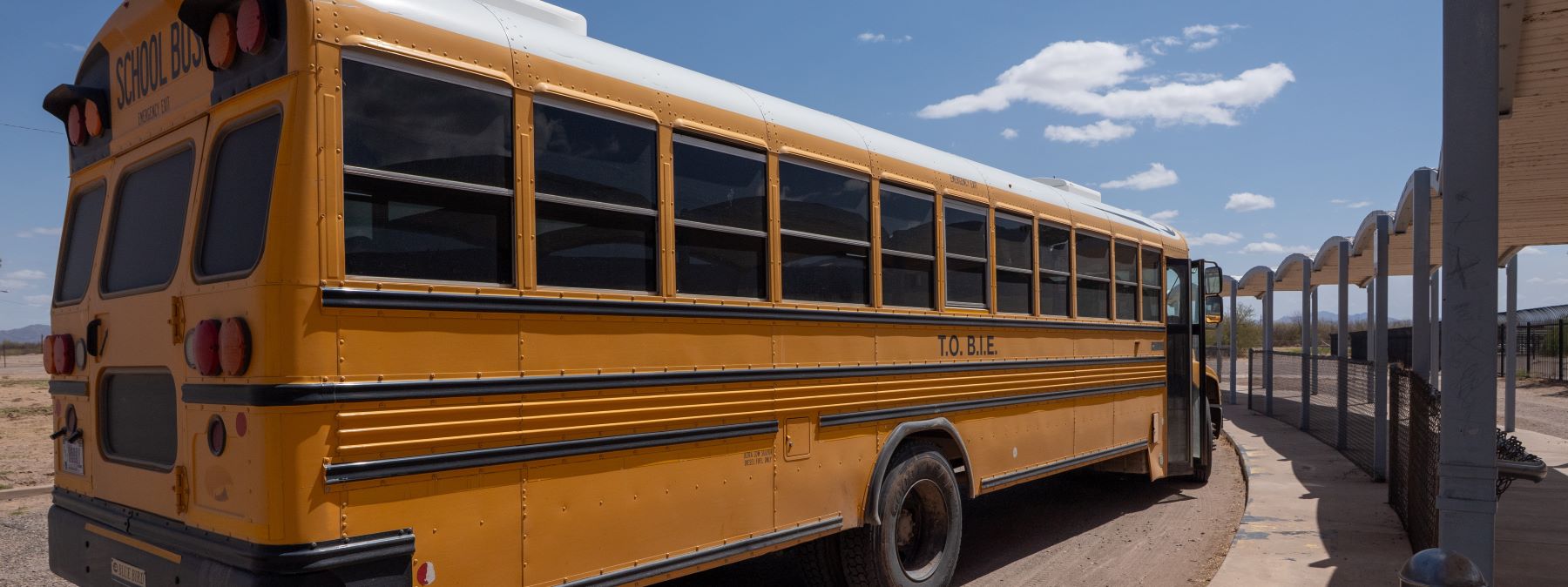 Yellow school bus parked outside waiting to pickup students.